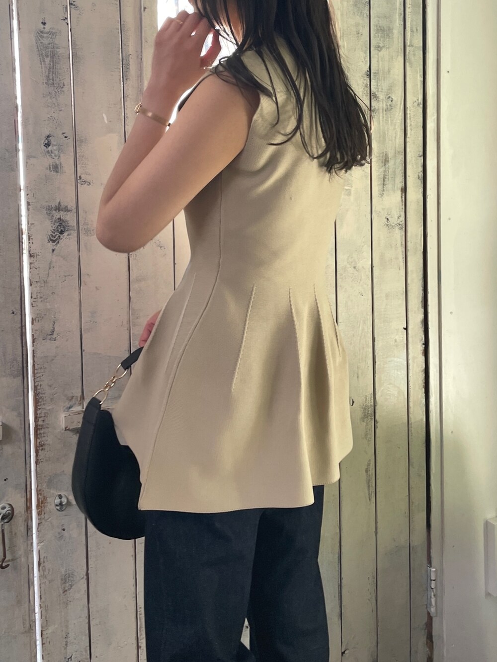 ベージュ系のニット/セーター、ブルー系のデニムパンツ、ベージュ系のサンダルを着用したレディースの春コーディネートの5枚目の写真