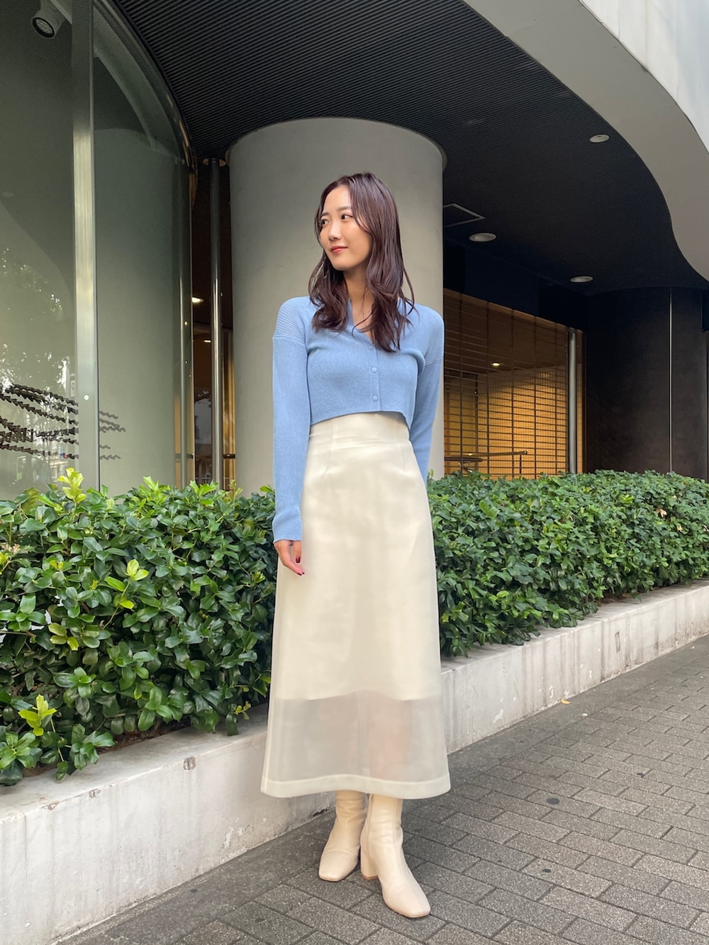 ホワイト系のブーツ、ホワイト系のスカート、ブルー系のカーディガン/ボレロを着用したレディースの秋コーディネートの3枚目の写真