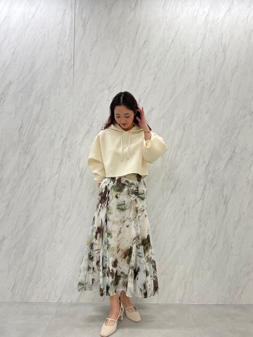 ホワイト系のパンプス、ベージュ系のスカート、ホワイト系のパーカーを着用したレディースの冬コーディネートの2枚目の写真