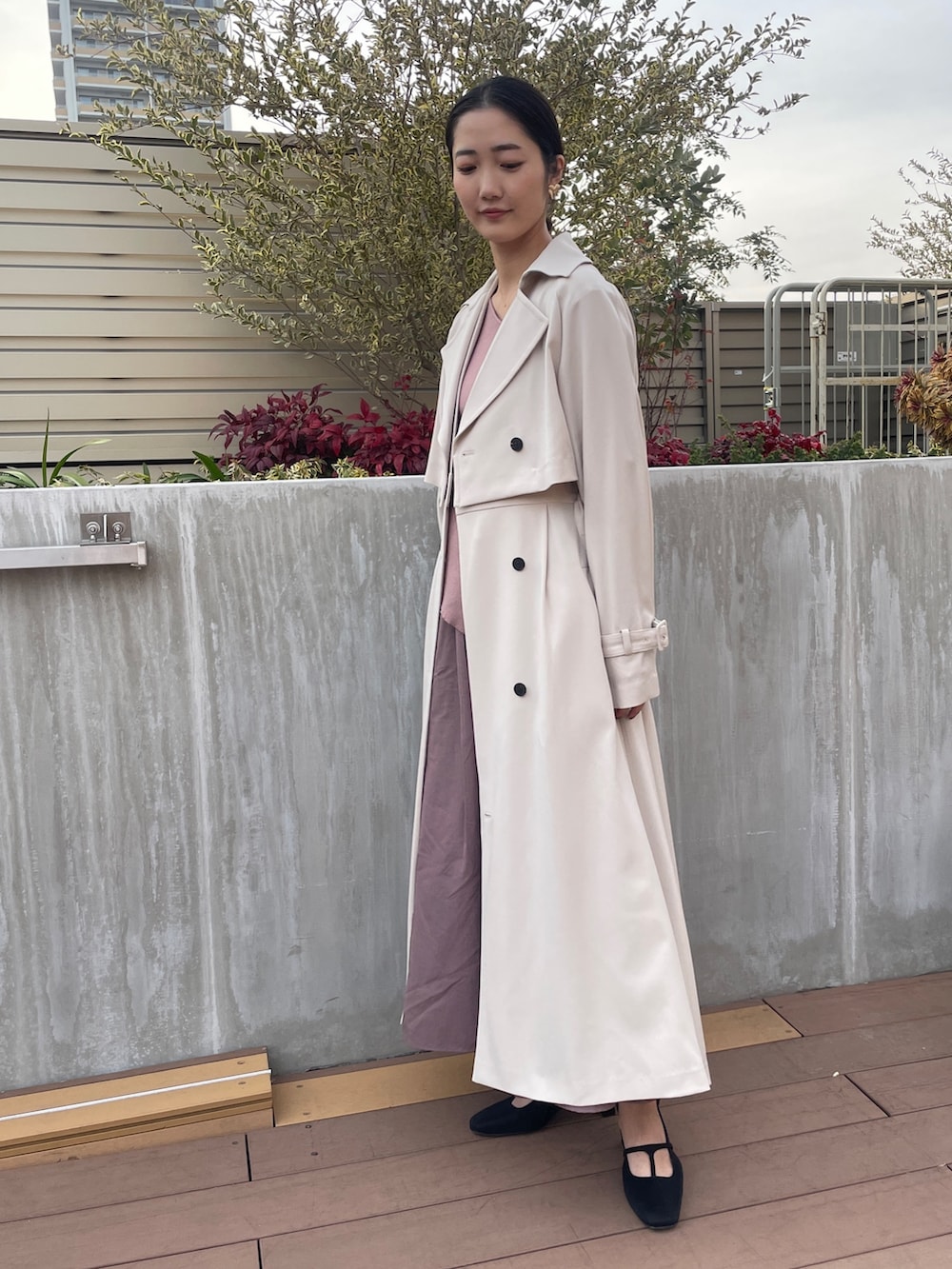 ホワイト系のトレンチコート、ブラック系のパンプス、ピンク系のワンピースを着用したレディースの冬コーディネートの4枚目の写真