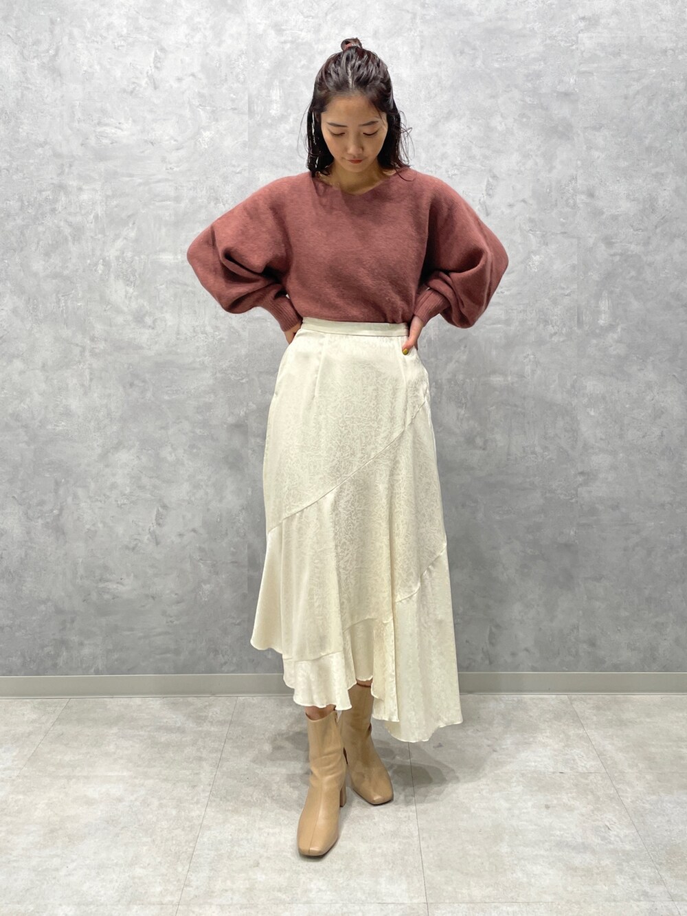 ベージュ系のブーツ、ホワイト系のスカート、ピンク系のニット/セーターを着用したレディースの冬コーディネートの3枚目の写真