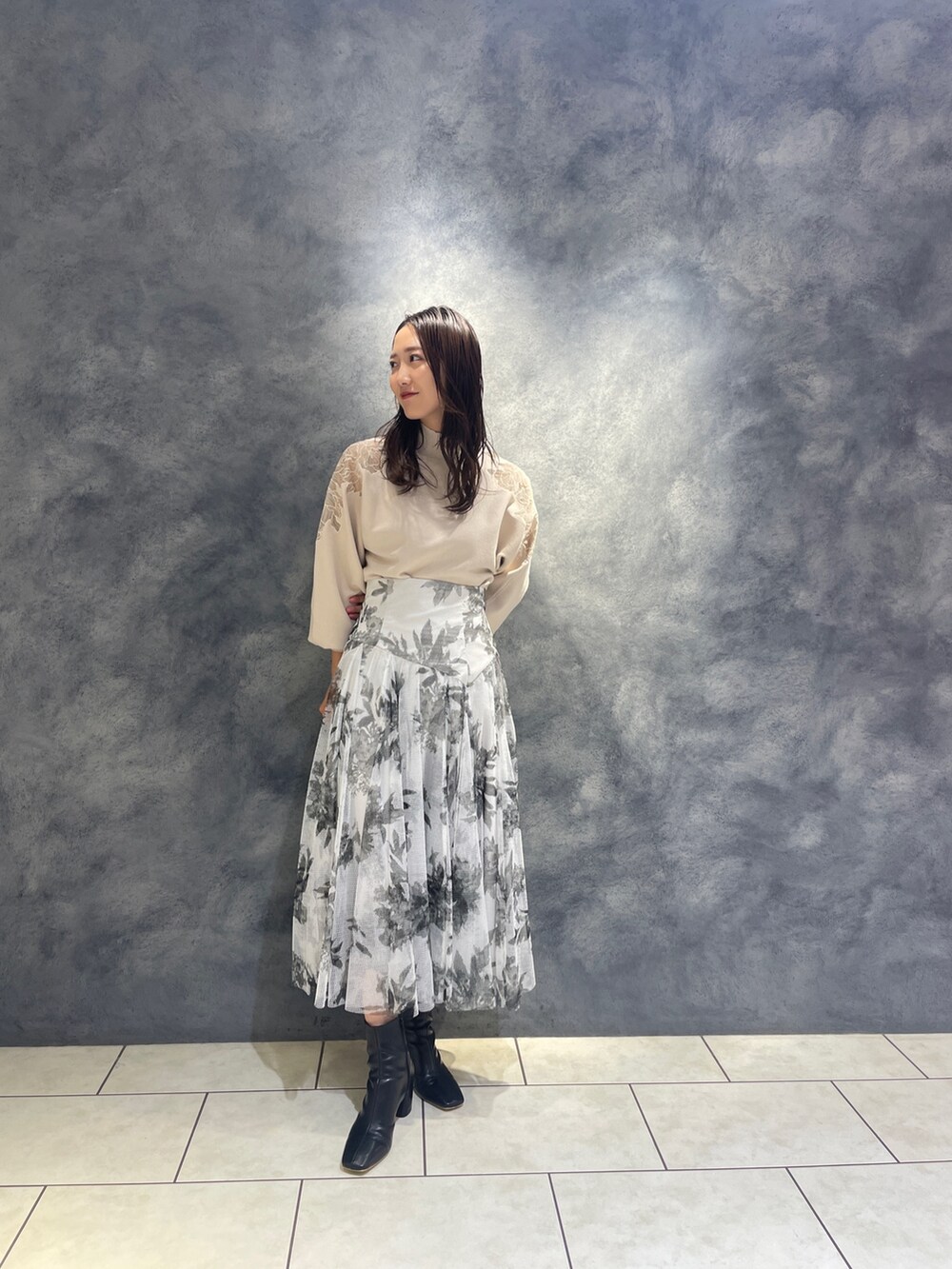 ホワイト系のニット/セーター、ブラック系のブーツ、ブラック系のスカートを着用したレディースの秋コーディネートの5枚目の写真