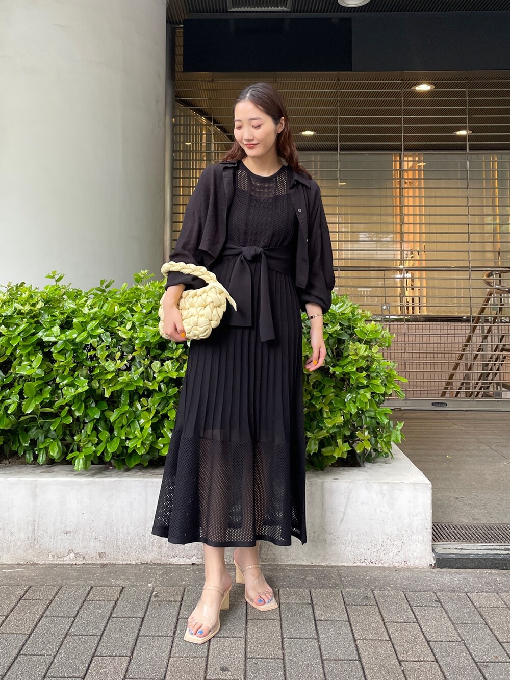 ブラック系のシャツ/ブラウス、ベージュ系のハンドバッグ、ブラック系のワンピースを着用したレディースの春コーディネートの2枚目の写真