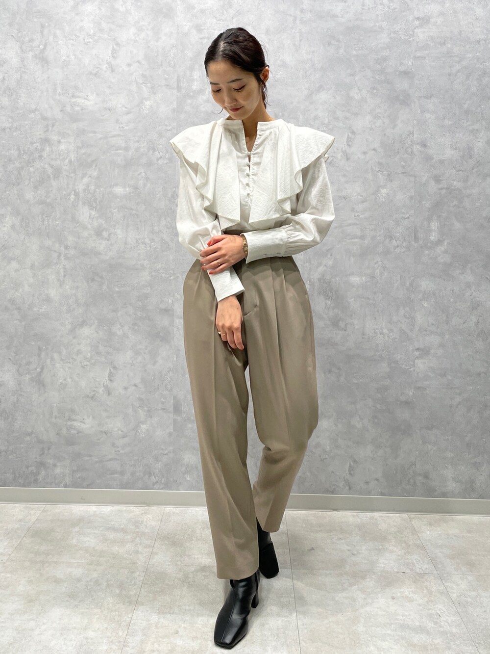 ホワイト系のカーディガン/ボレロ、ブラック系のブーツ、ホワイト系のシャツ/ブラウスを着用したレディースの冬コーディネートの5枚目の写真