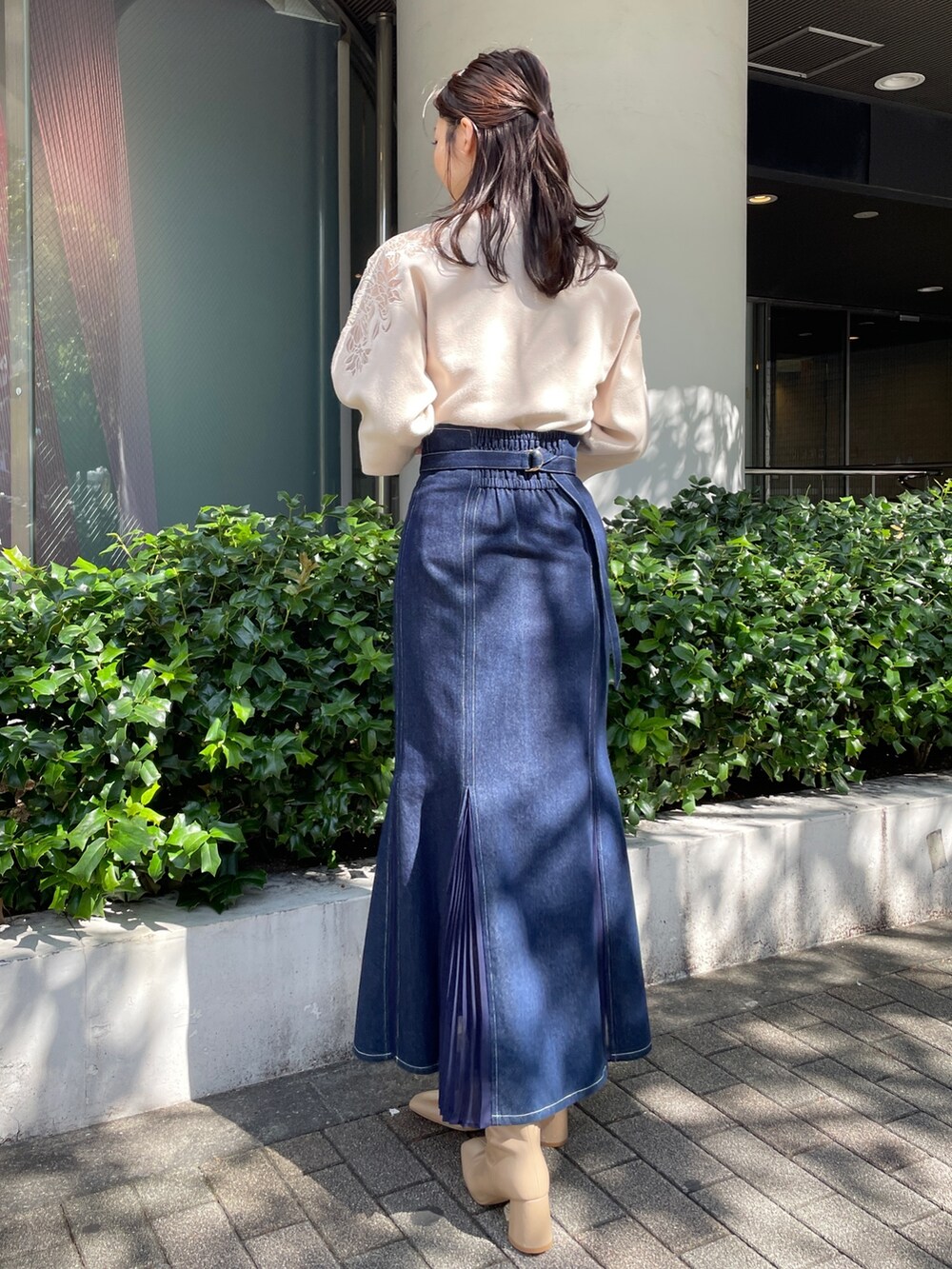 ベージュ系のブーツ、ブルー系のスカート、ホワイト系のニット/セーターを着用したレディースの秋コーディネートの8枚目の写真