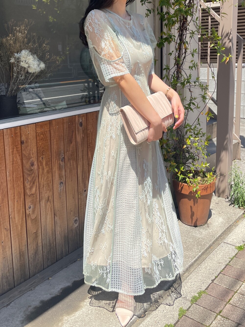 グリーン系のドレス、ベージュ系のハンドバッグ、ベージュ系のパンプスを着用したレディースの春コーディネートの6枚目の写真