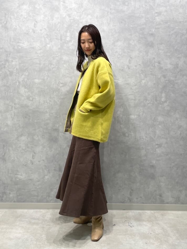 ベージュ系のブーツ、ブラウン系のスカート、イエロー系のカーディガン/ボレロを着用したレディースの秋コーディネートの2枚目の写真