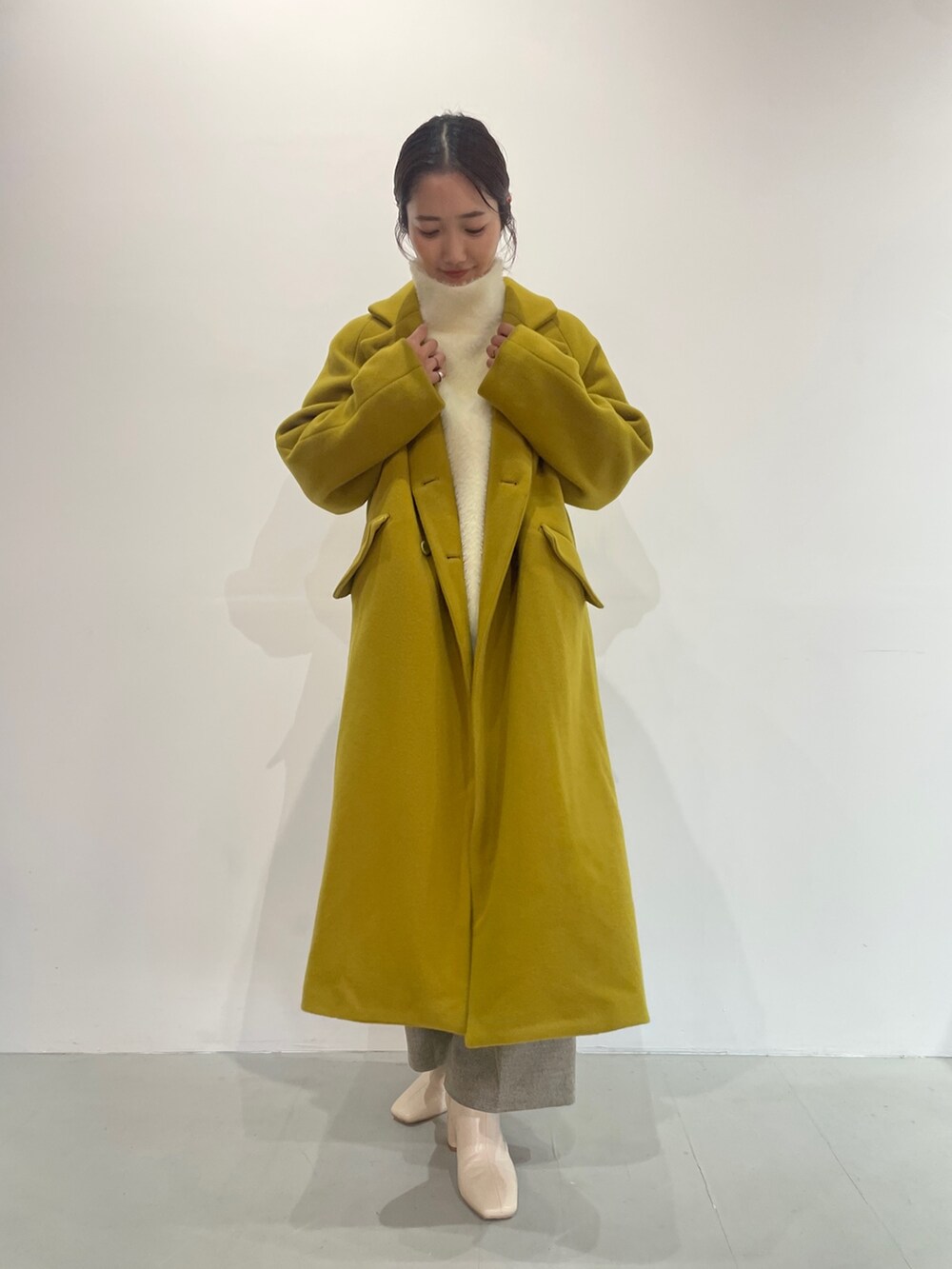 ホワイト系のニット/セーター、ベージュ系のその他パンツ、ホワイト系のブーツを着用したレディースの夏コーディネートの2枚目の写真