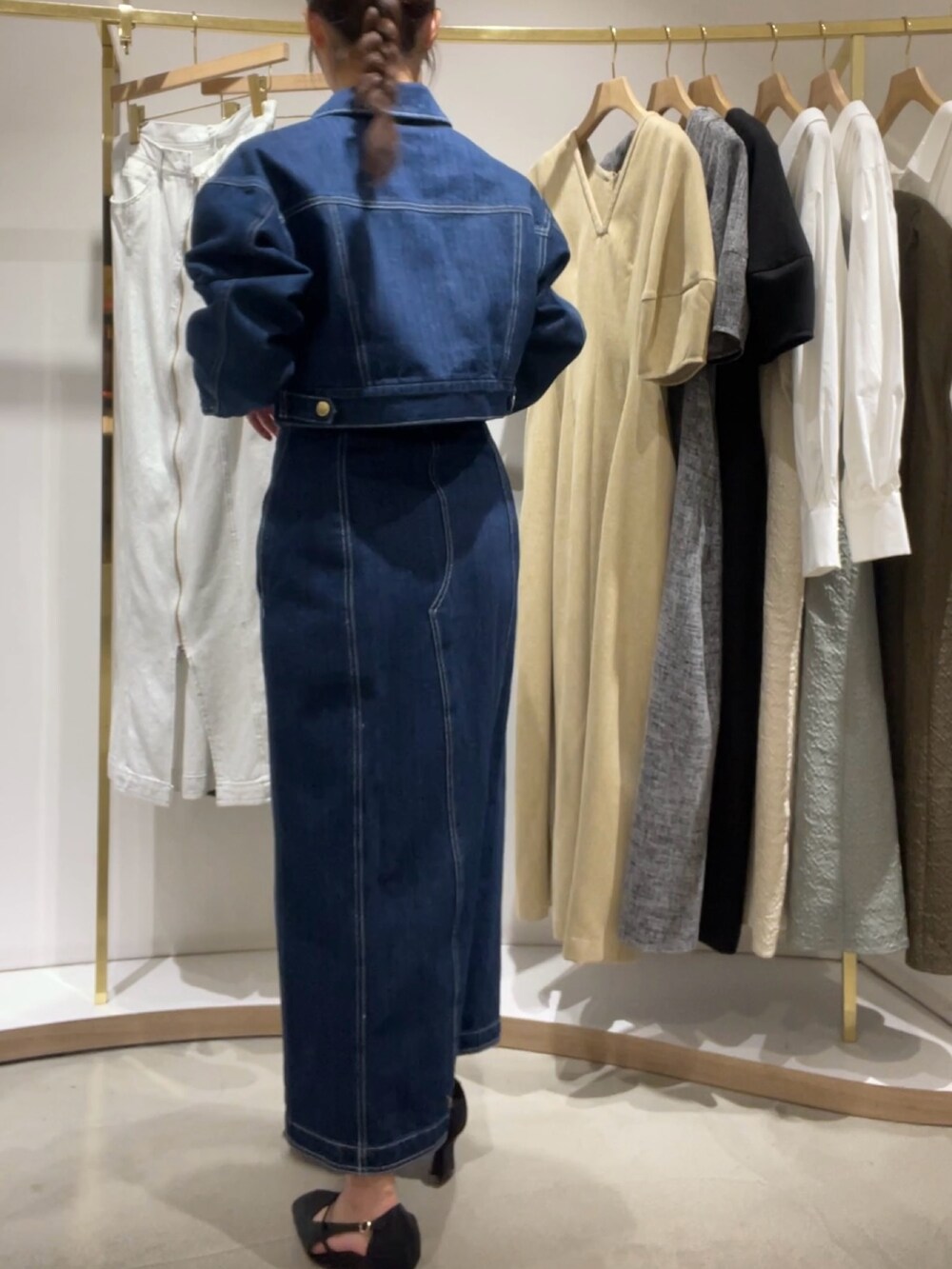 ブルー系のワンピース、ブルー系のデニムジャケット、ブラック系のパンプスを着用したレディースの冬コーディネートの3枚目の写真