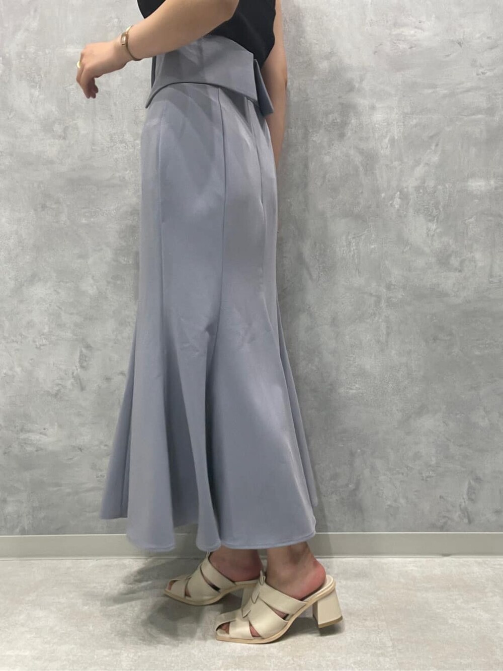 ホワイト系のサンダル、ブラック系のニット/セーター、ブルー系のスカートを着用したレディースの夏コーディネートの9枚目の写真