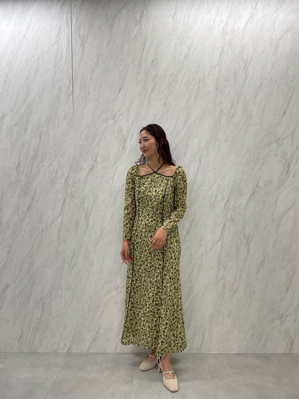 ホワイト系のパンプス、グリーン系のワンピースを着用したレディースの冬コーディネートの4枚目の写真