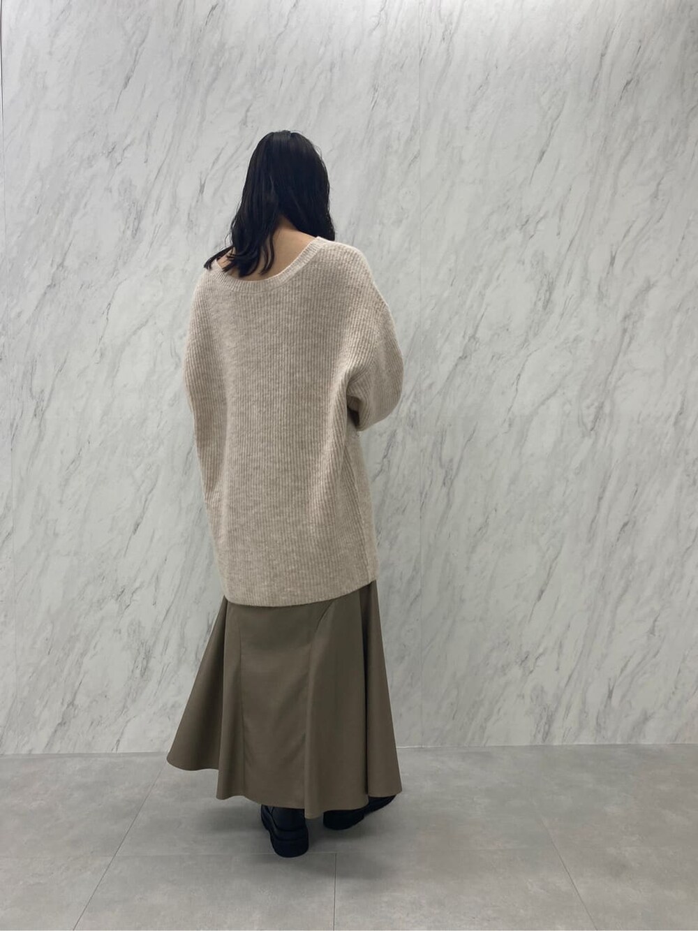 ブラック系のブーツ、ベージュ系のスカート、ホワイト系のカーディガン/ボレロを着用したレディースの秋コーディネートの7枚目の写真