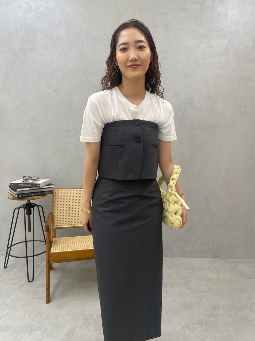 グレー系のスカート、ホワイト系のTシャツ/カットソー、ベージュ系のハンドバッグを着用したレディースの春コーディネートの7枚目の写真