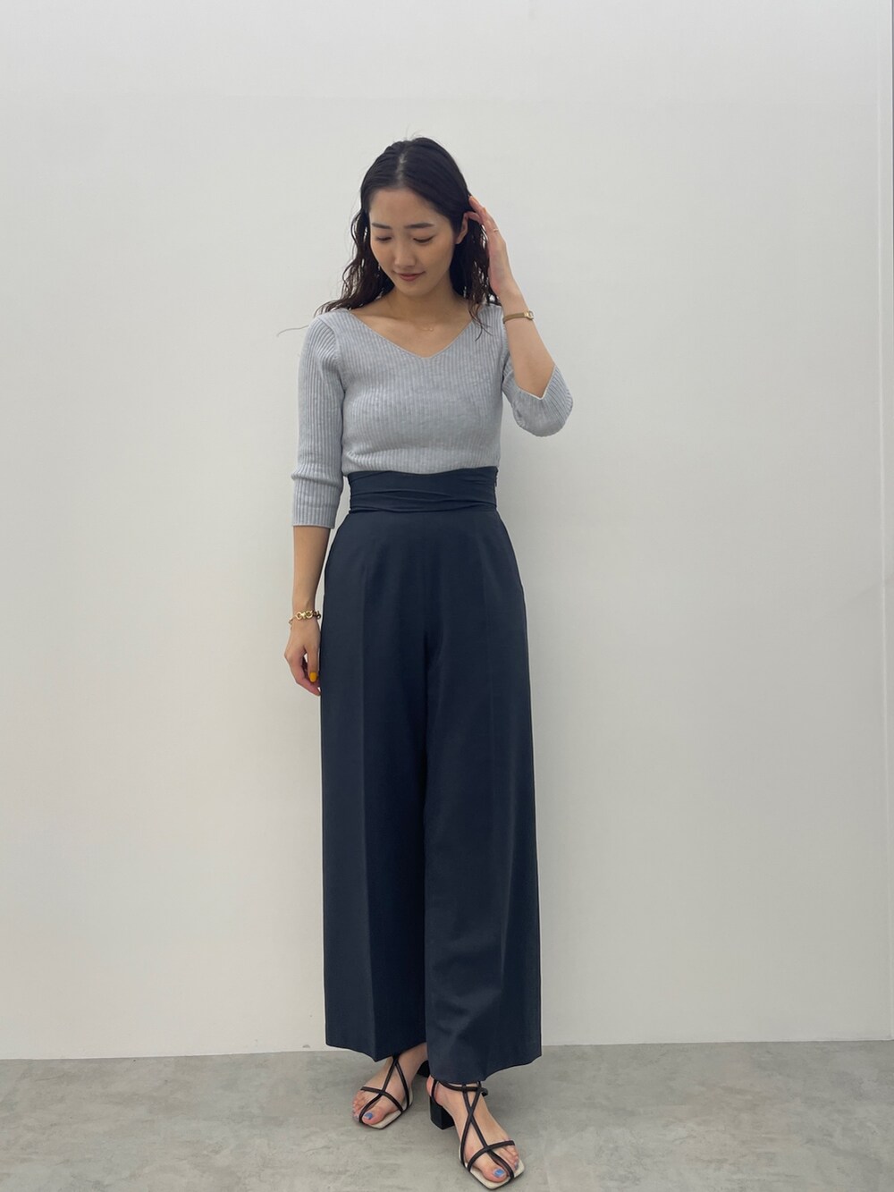 ブラック系のサンダル、ブルー系のスラックス、ブルー系のニット/セーターを着用したレディースの春コーディネートの4枚目の写真