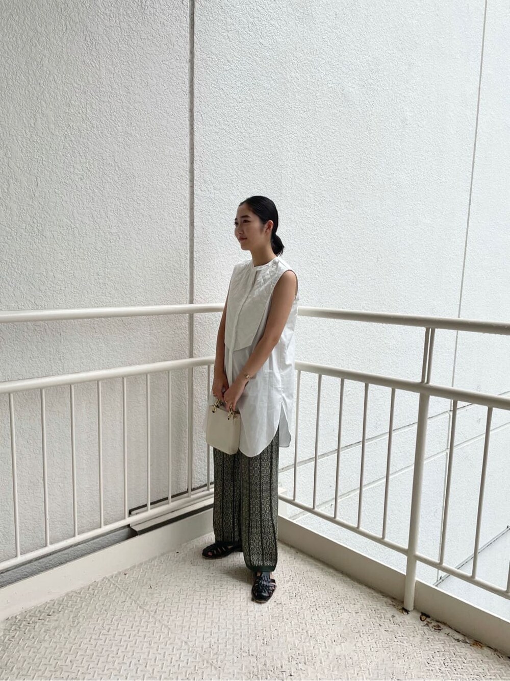 ホワイト系のシャツ/ブラウス、ベージュ系のその他パンツ、ホワイト系のショルダーバッグを着用したレディースの夏コーディネートの5枚目の写真