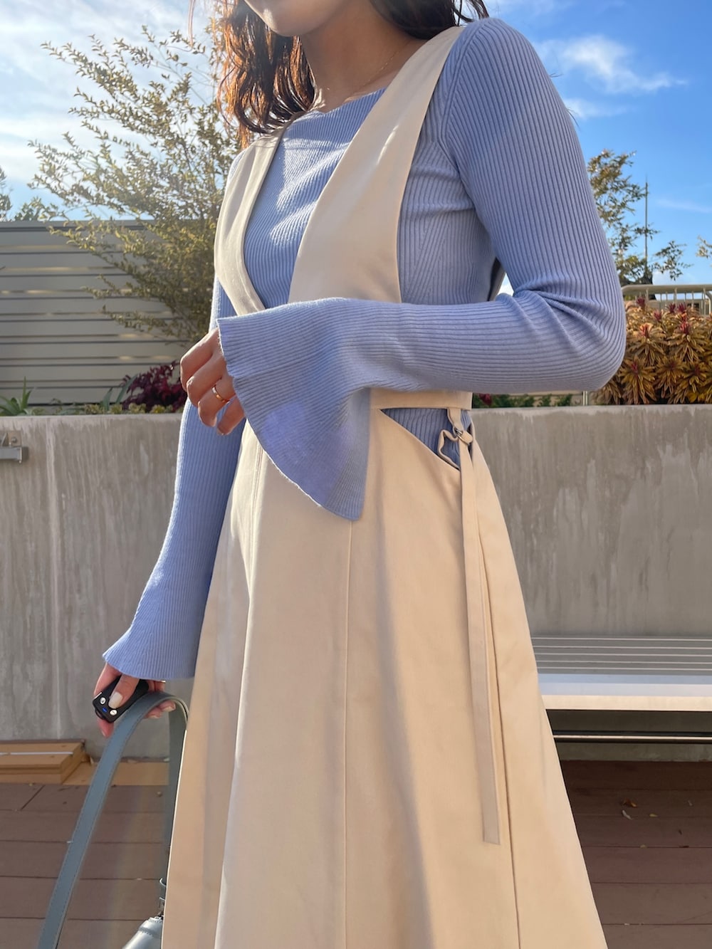 ブルー系のニット/セーター、ベージュ系のブーツ、ホワイト系のジャンパースカートを着用したレディースの冬コーディネートの7枚目の写真