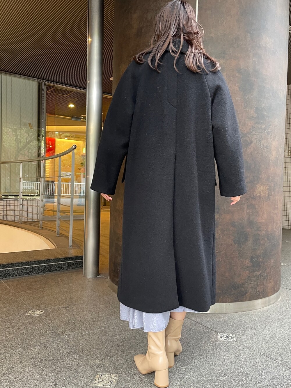 ベージュ系のニット/セーター、ベージュ系のブーツ、ブラック系のその他アウターを着用したレディースの冬コーディネートの4枚目の写真