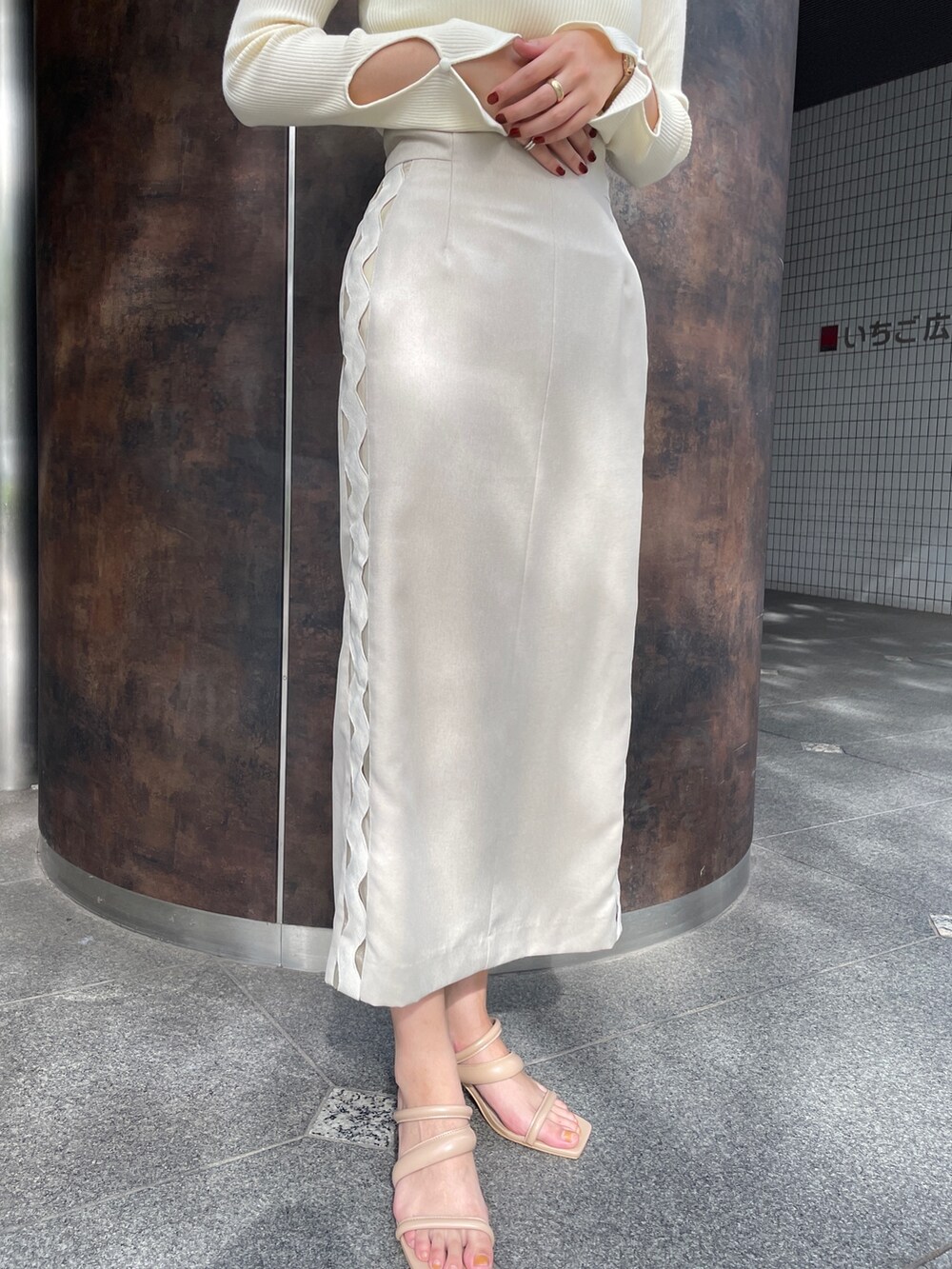 ベージュ系のサンダル、ベージュ系のスカート、ホワイト系のニット/セーターを着用したレディースの冬コーディネートの8枚目の写真