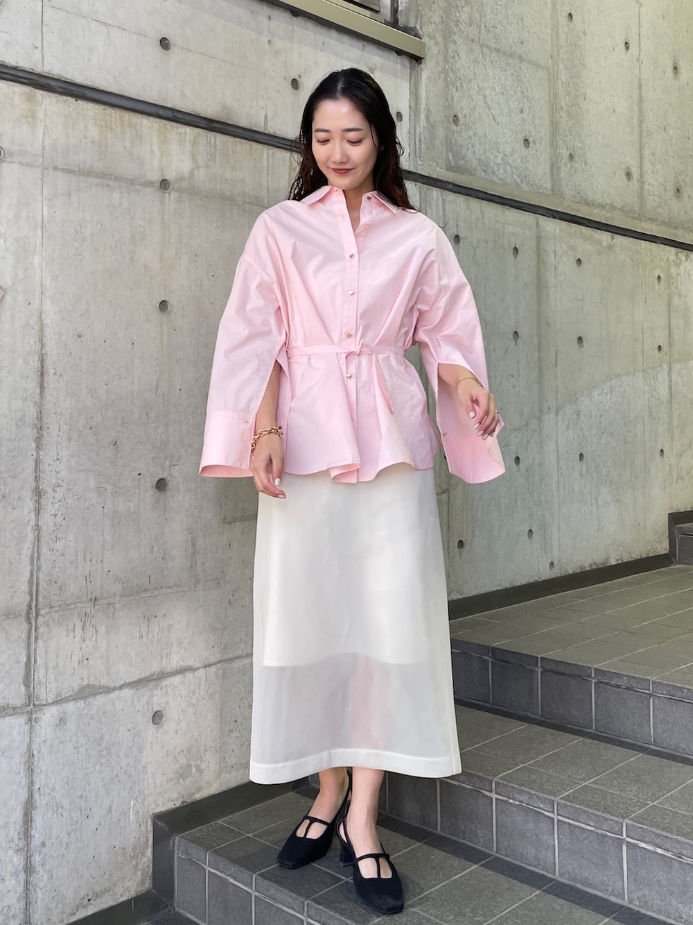 ピンク系のシャツ/ブラウス、ブラック系のパンプス、ホワイト系のスカートを着用したレディースの冬コーディネートの3枚目の写真