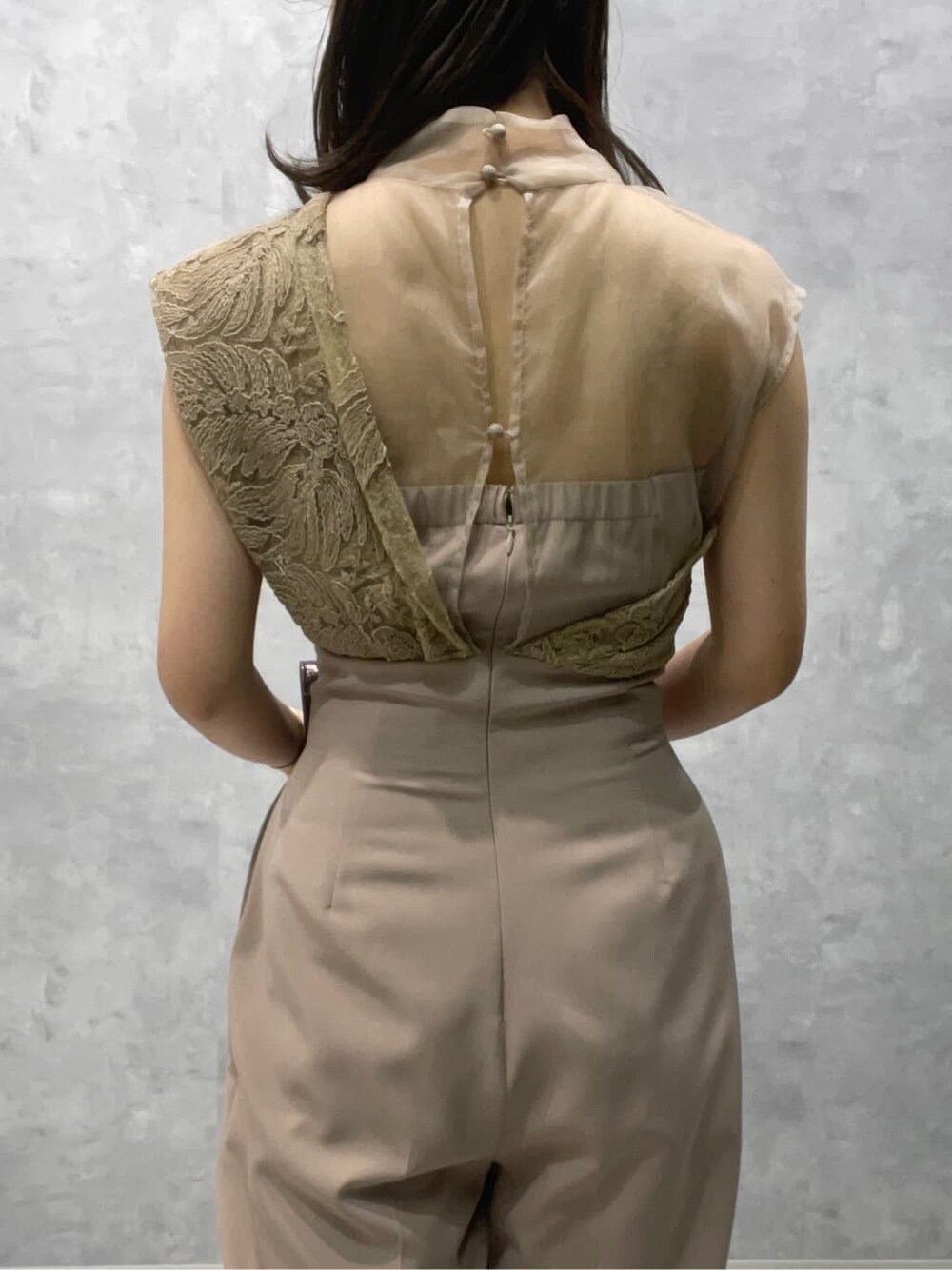 シルバー系のパンプス、シルバー系のクラッチバッグ、ベージュ系のパンツドレスを着用したレディースの夏コーディネートの5枚目の写真