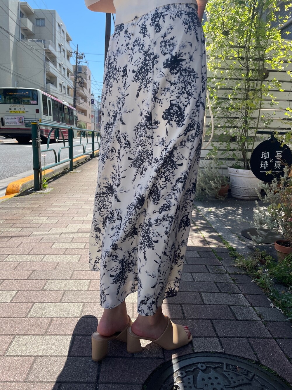 ベージュ系のハンドバッグ、ホワイト系のカーディガン/ボレロ、ブルー系のスカートを着用したレディースの春コーディネートの9枚目の写真