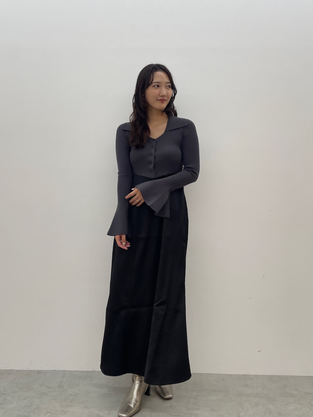 グレー系のワンピース、シルバー系のブーツを着用したレディースの秋コーディネートの2枚目の写真