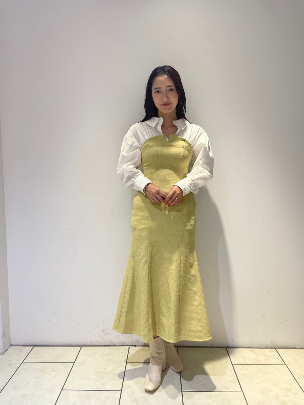 イエロー系のワンピース、ホワイト系のブーツを着用したレディースの秋コーディネートの4枚目の写真