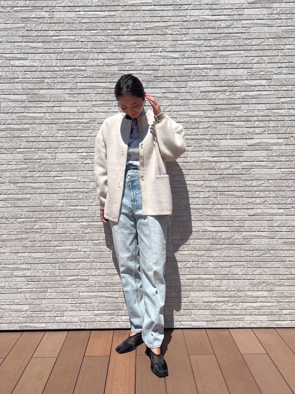 ブルー系のデニムパンツ、ブルー系のシャツ/ブラウス、ホワイト系のカーディガン/ボレロを着用したレディースの秋コーディネートの2枚目の写真