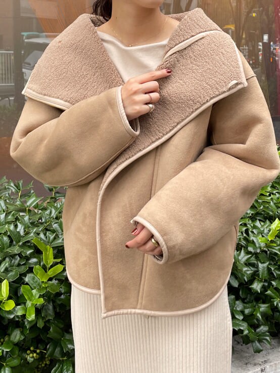 ベージュ系のブーツ、ブラウン系のブルゾン、ホワイト系のワンピースを着用したレディースの秋コーディネートの6枚目の写真