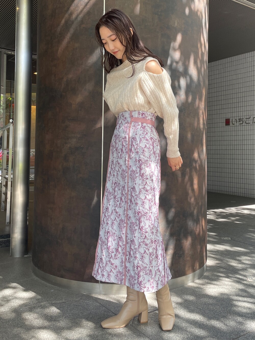 ホワイト系のニット/セーター、ベージュ系のブーツ、ピンク系のスカートを着用したレディースの秋コーディネートの7枚目の写真