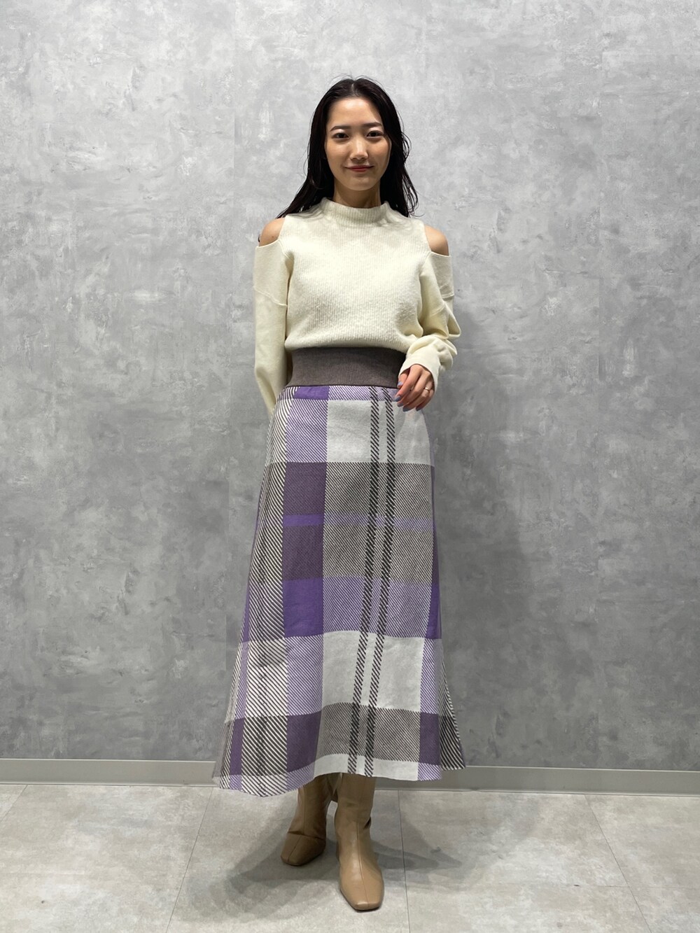 ベージュ系のブーツ、ホワイト系のニット/セーター、パープル系のスカートを着用したレディースの冬コーディネートの3枚目の写真