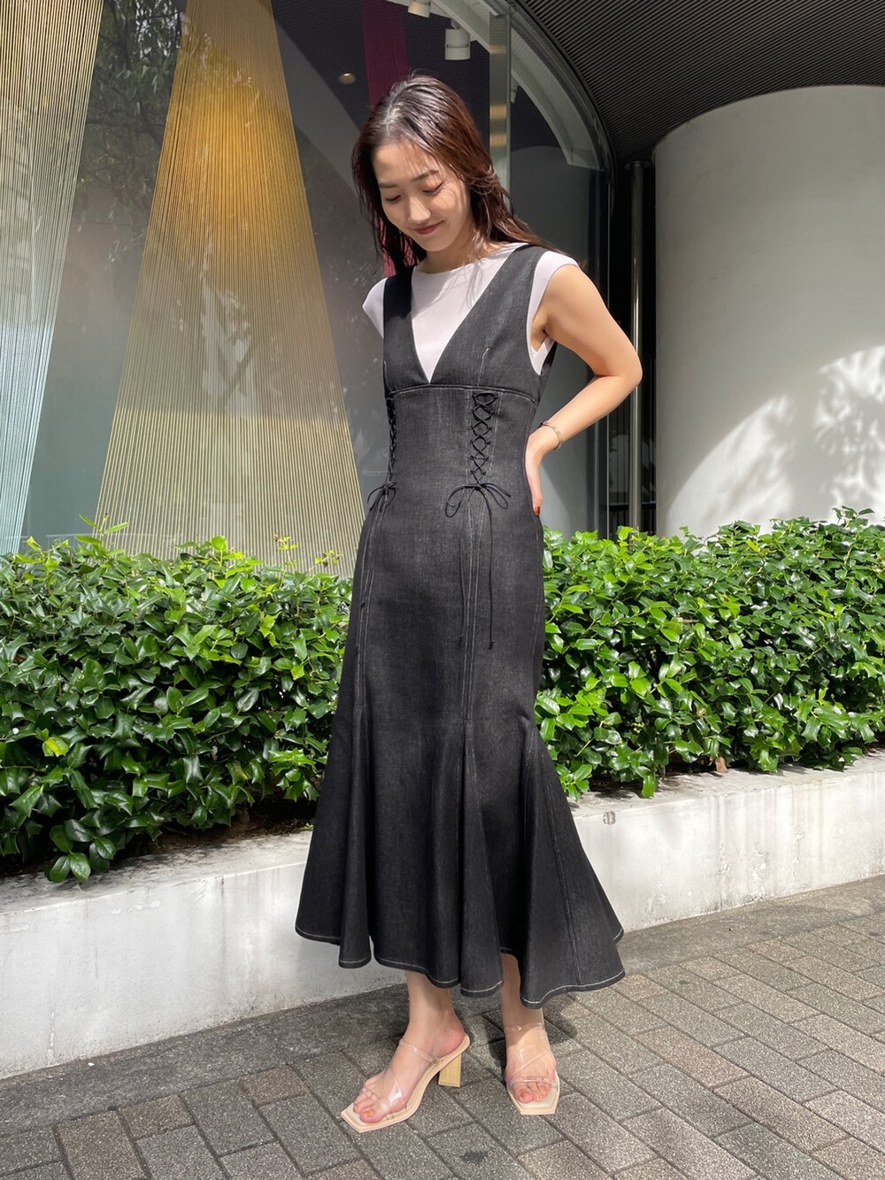 ブラック系のデニムジャケット、ブラック系のワンピース、その他のサンダルを着用したレディースの冬コーディネートの4枚目の写真