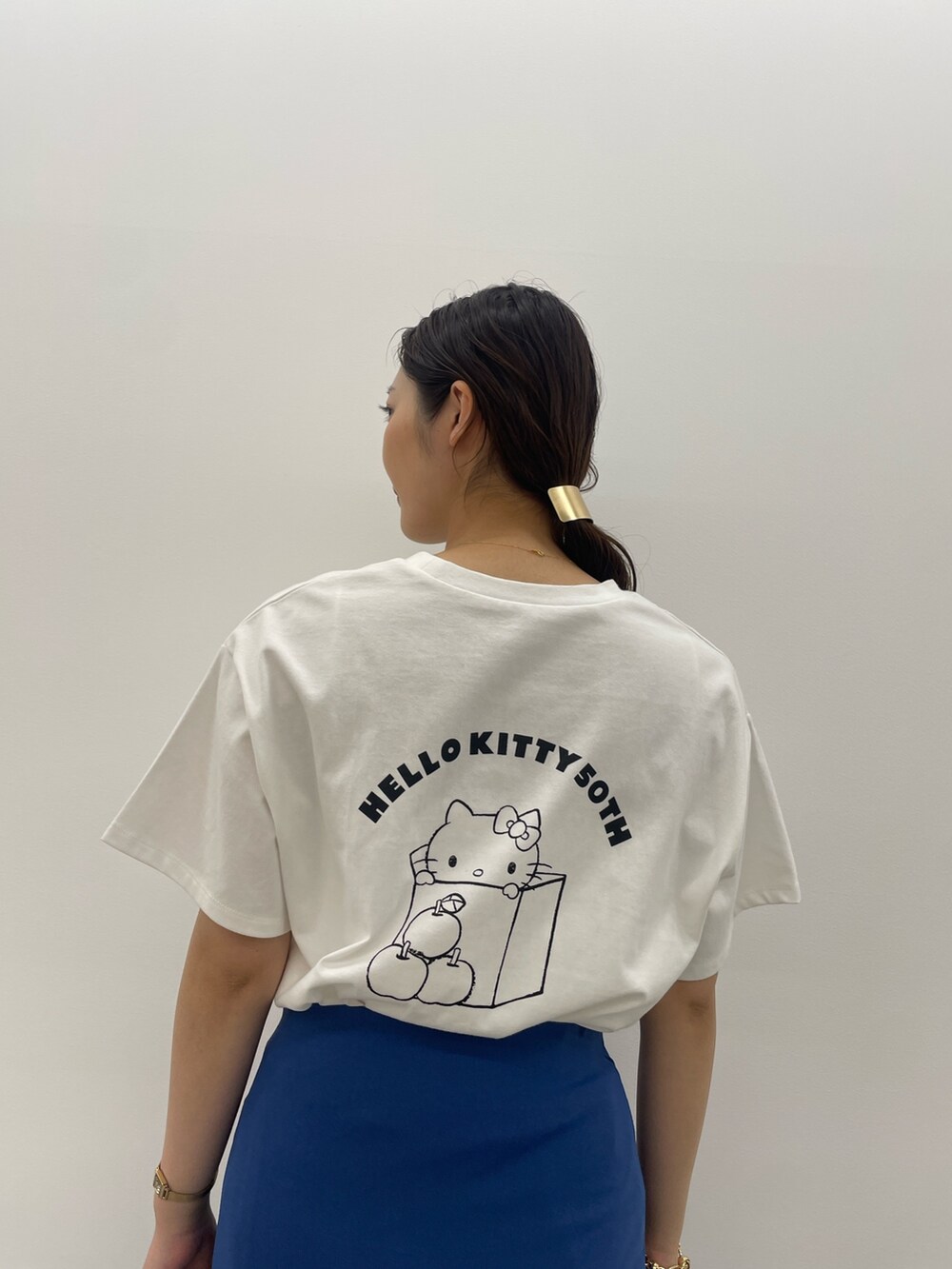 ブルー系のスカート、ホワイト系のTシャツ/カットソー、ブラック系のサンダルを着用したレディースの春コーディネートの7枚目の写真