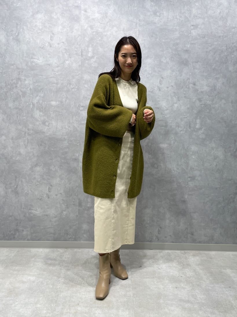 ベージュ系のブーツ、ホワイト系のニット/セーター、ホワイト系のスカートを着用したレディースの秋コーディネートの2枚目の写真