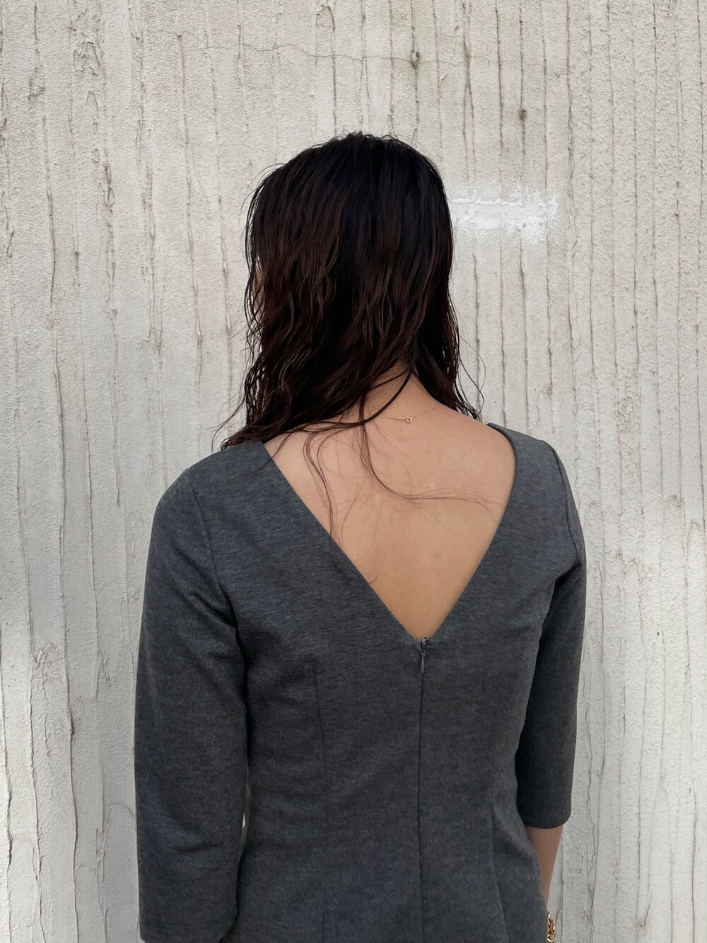 ブラック系のショルダーバッグ、グレー系のワンピース、ホワイト系のスニーカーを着用したレディースの冬コーディネートの6枚目の写真