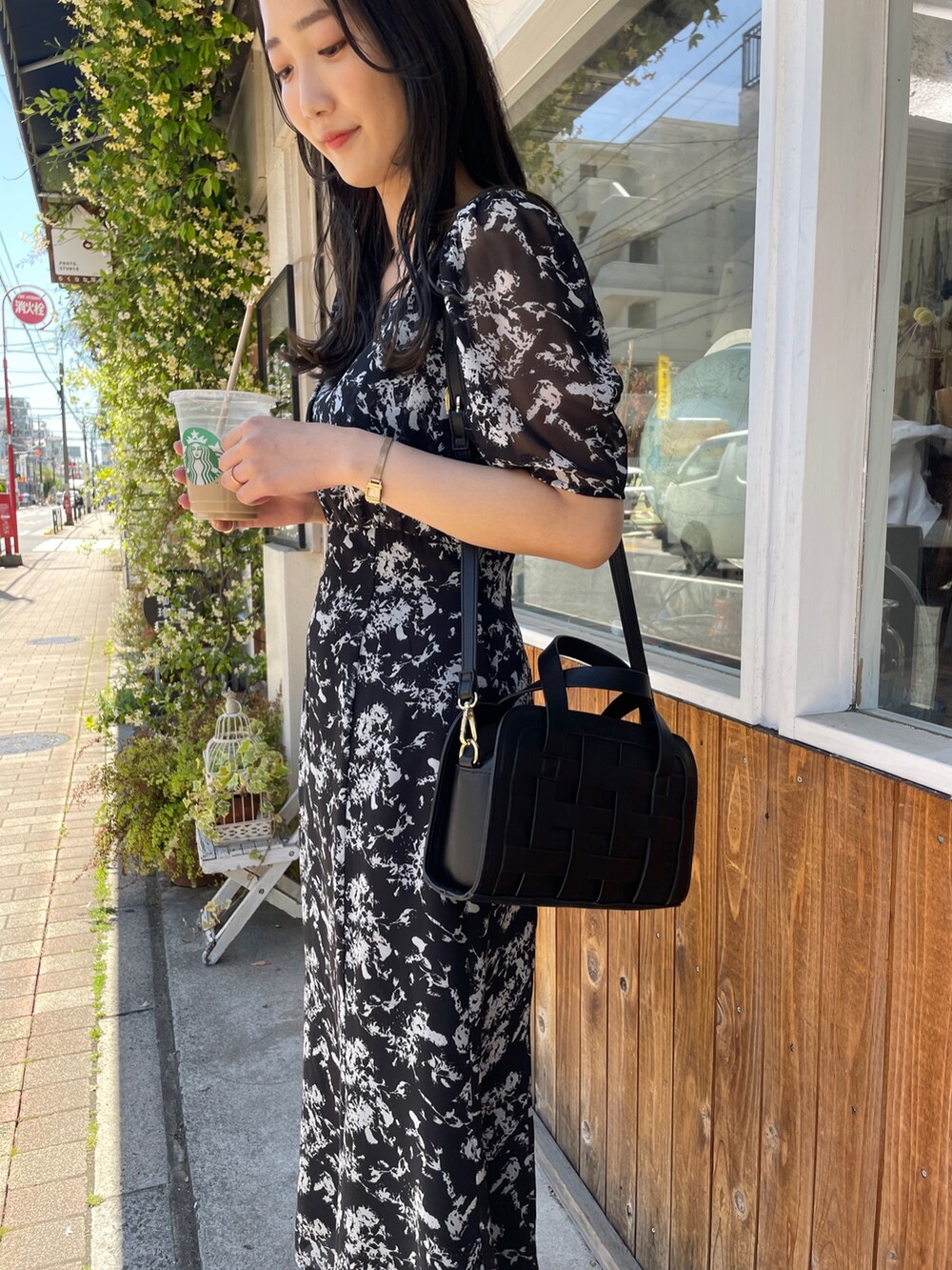 ブラック系のショルダーバッグ、ブラック系のワンピース、ブラック系のパンプスを着用したレディースの春コーディネートの5枚目の写真