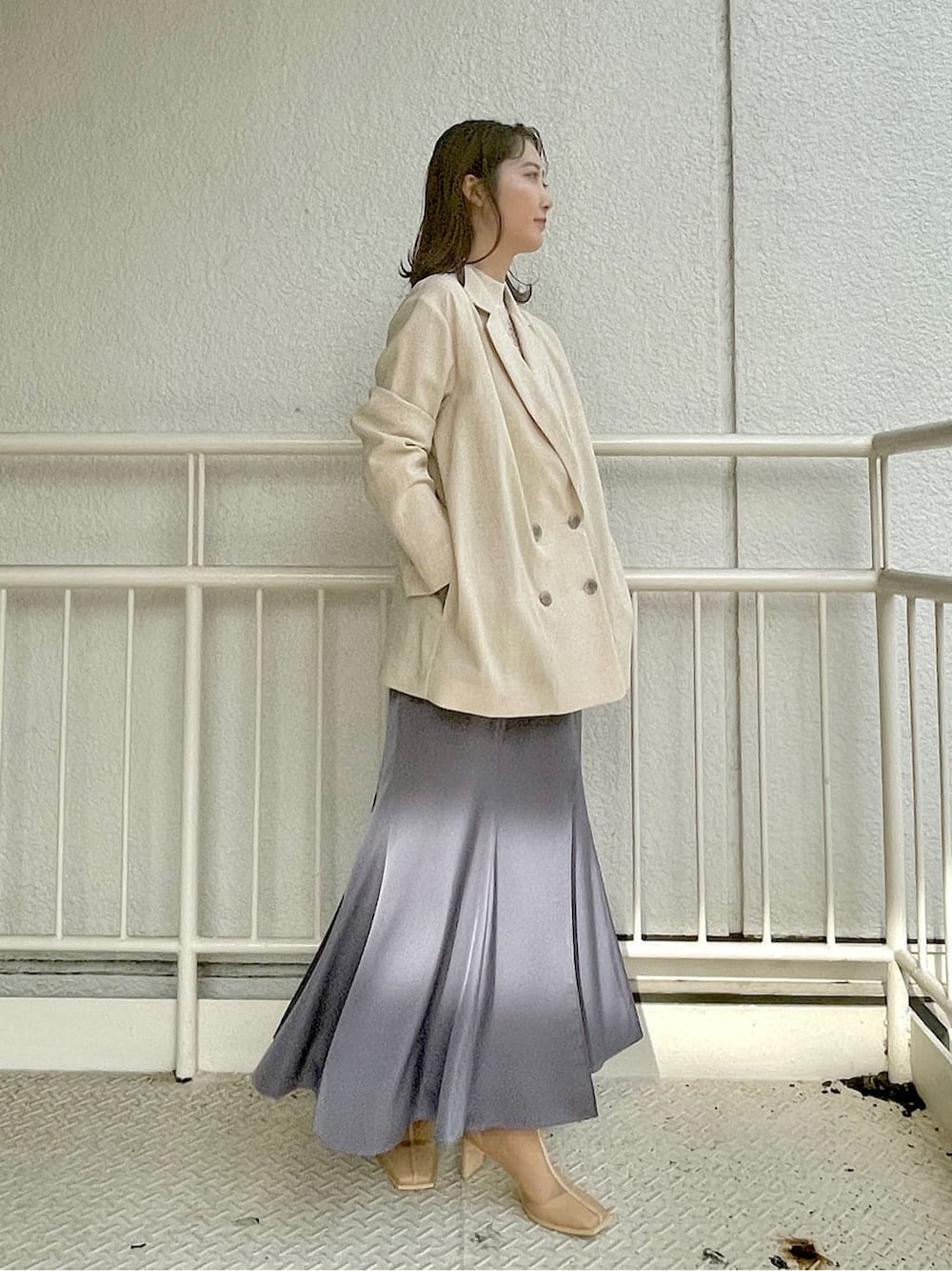 ホワイト系のニット/セーター、ベージュ系のブーツ、ブルー系のスカートを着用したレディースの春コーディネートの2枚目の写真