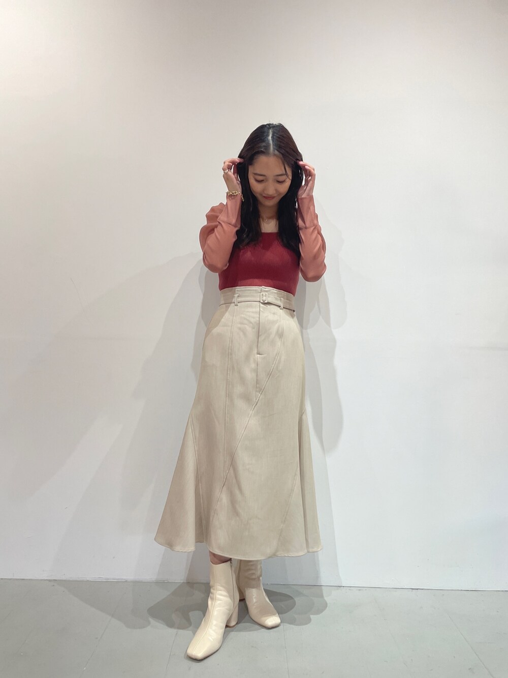 ホワイト系のブーツ、ベージュ系のスカート、ピンク系のニット/セーターを着用したレディースの夏コーディネートの4枚目の写真