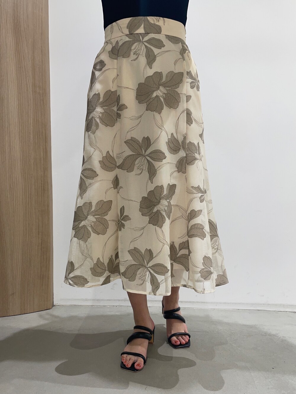 ブラック系のニット/セーター、ブラック系のサンダル、ベージュ系のスカートを着用したレディースの春コーディネートの10枚目の写真