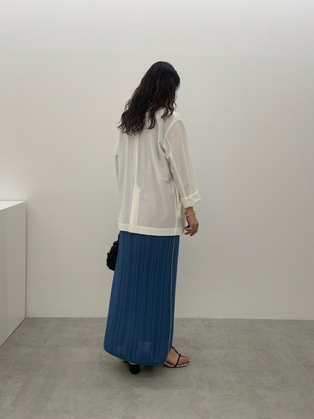 ブラック系のサンダル、ホワイト系のテーラードジャケット、ブルー系のワンピースを着用したレディースの夏コーディネートの4枚目の写真