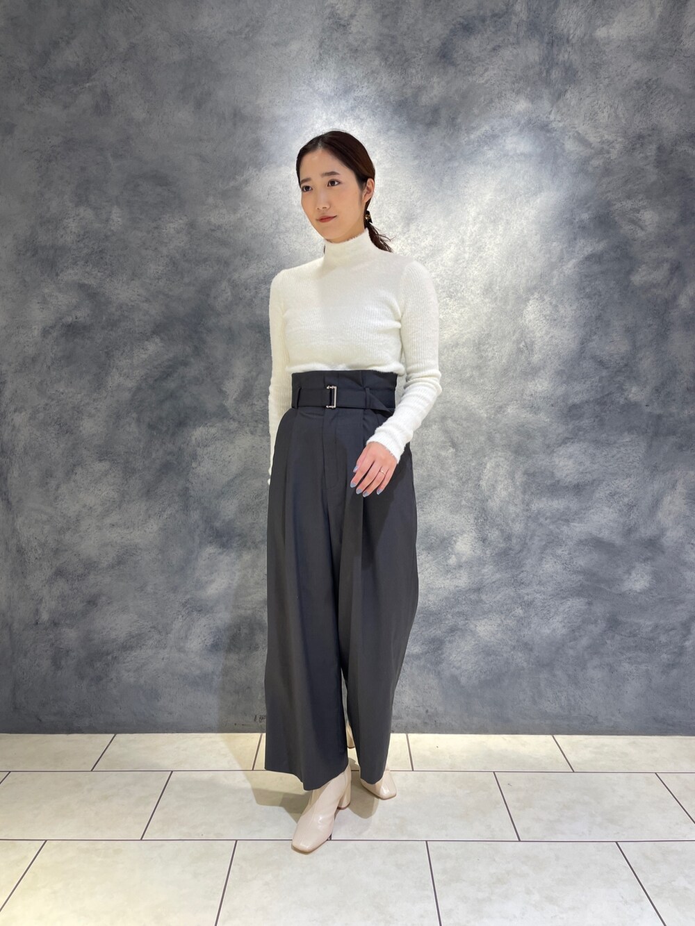 グレー系のその他パンツ、ホワイト系のニット/セーター、ホワイト系のブーツを着用したレディースの冬コーディネートの2枚目の写真
