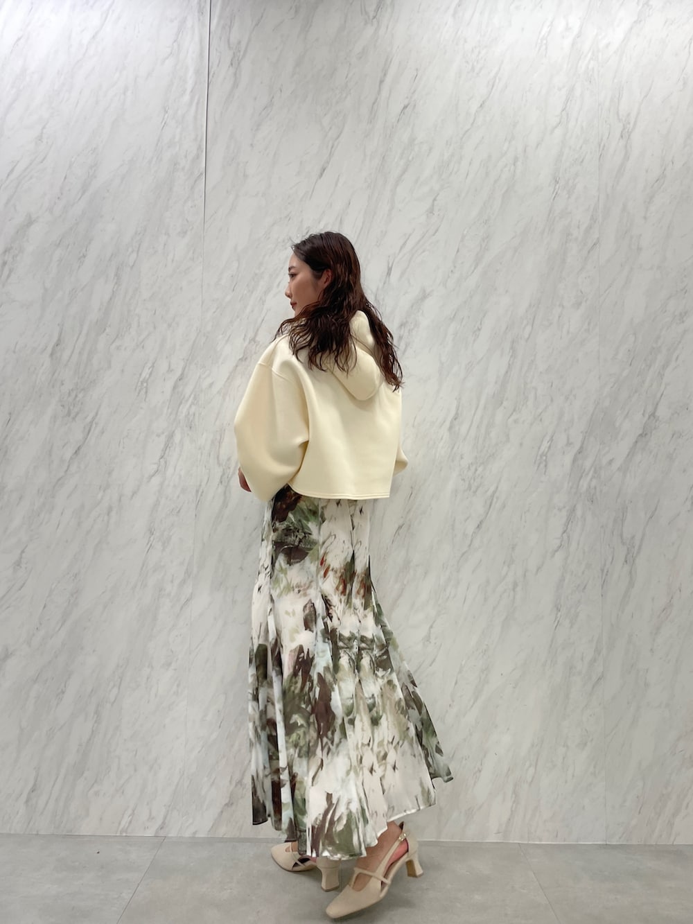 ホワイト系のパンプス、ベージュ系のスカート、ホワイト系のパーカーを着用したレディースの冬コーディネートの5枚目の写真