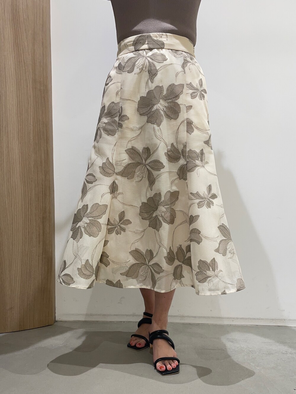 ベージュ系のスカート、ベージュ系のニット/セーター、ブラック系のサンダルを着用したレディースの春コーディネートの7枚目の写真