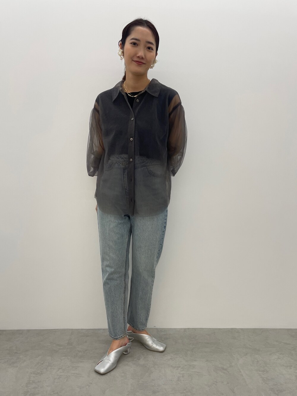 ブルー系のデニムパンツ、シルバー系のパンプス、ブラック系のニット/セーターを着用したレディースの夏コーディネートの4枚目の写真