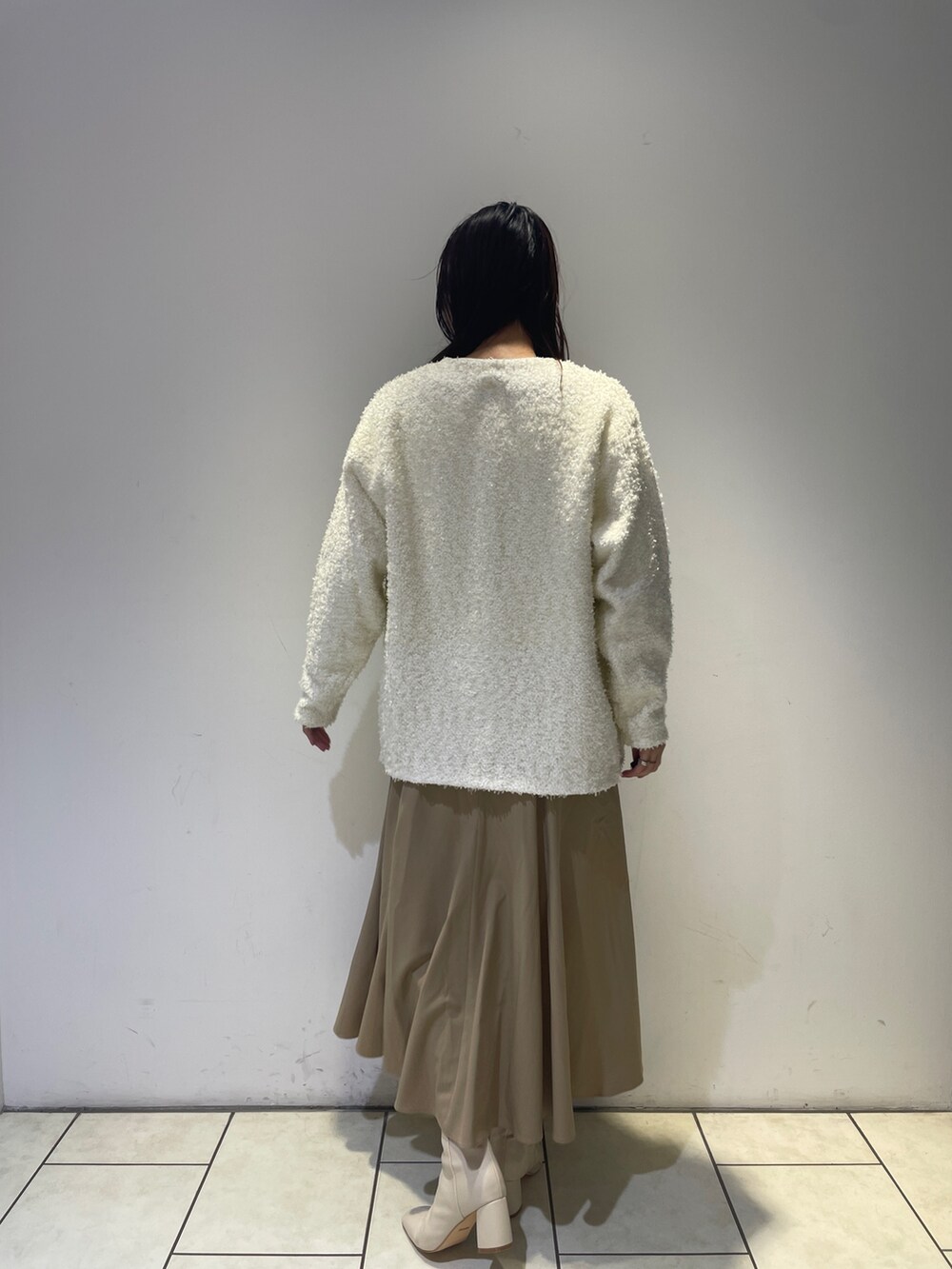 ベージュ系のワンピース、ホワイト系のブーツ、ホワイト系のカーディガン/ボレロを着用したレディースの秋コーディネートの5枚目の写真