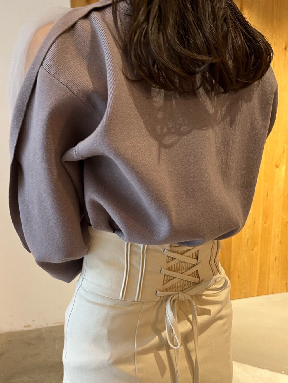 ブラック系のブーツ、ホワイト系のスカート、ベージュ系のニット/セーターを着用したレディースの冬コーディネートの8枚目の写真