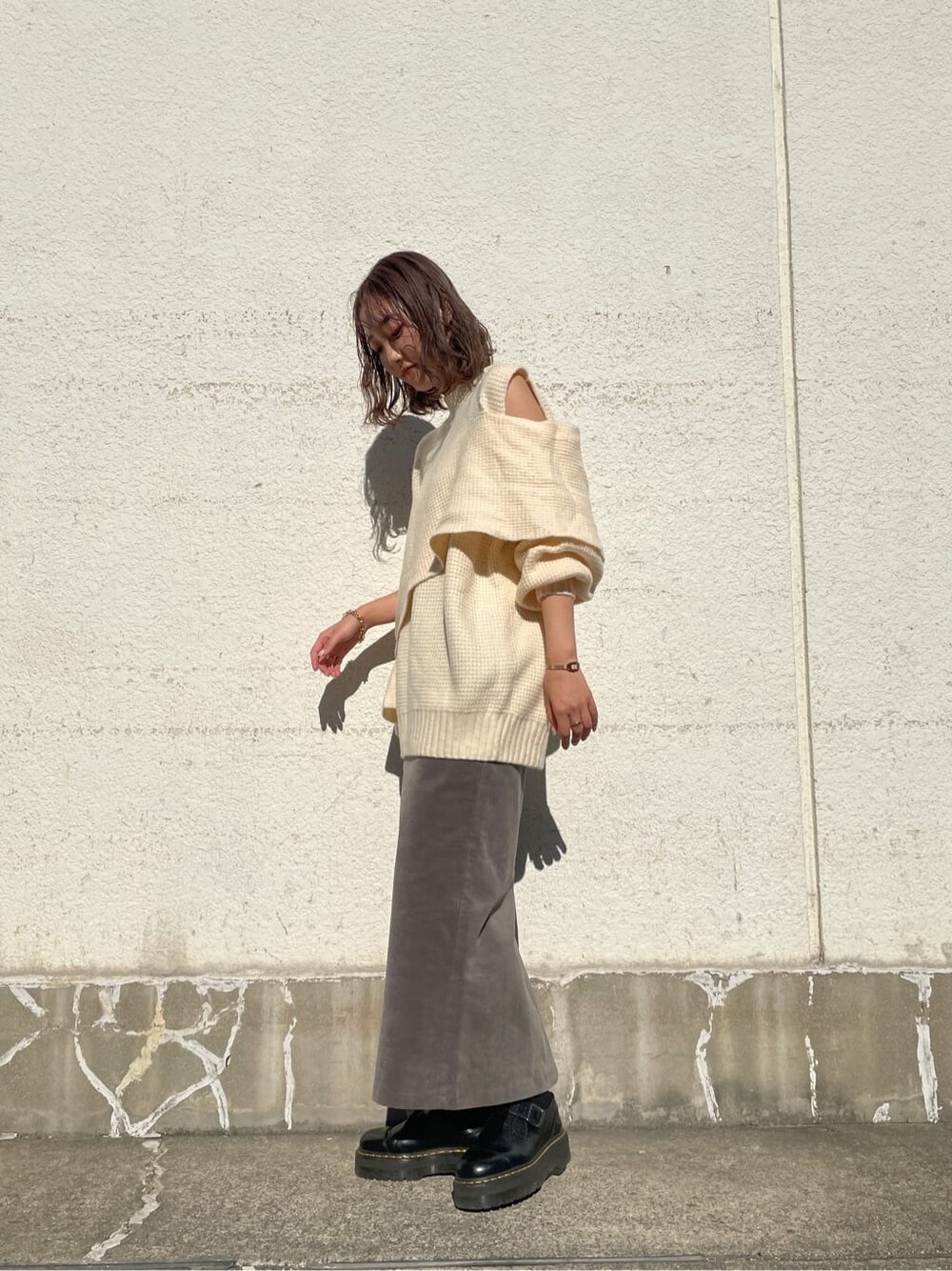 グレー系のスカート、ホワイト系のニット/セーターを着用したレディースの冬コーディネートの3枚目の写真