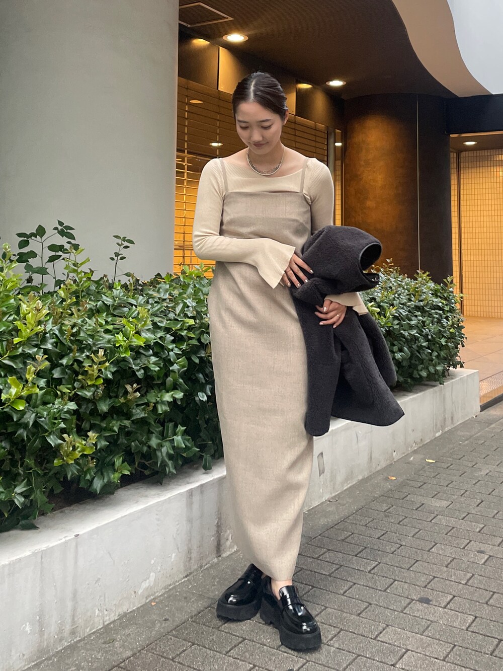 ベージュ系のワンピース、ホワイト系のニット/セーター、ブラック系のローファーを着用したレディースの秋コーディネートの3枚目の写真