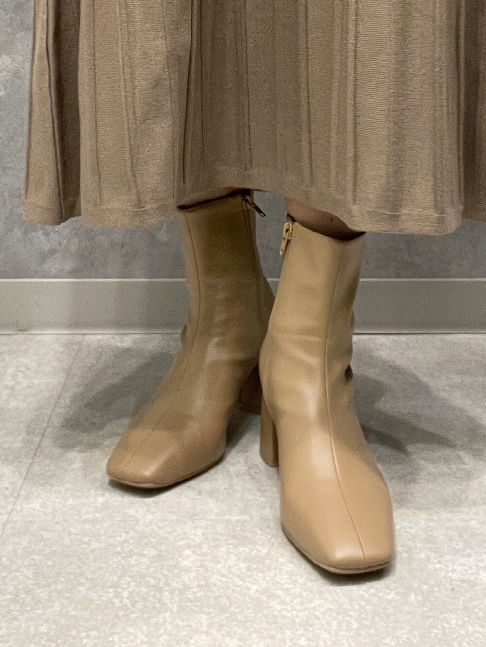 ホワイト系のワンピース、ベージュ系のブーツを着用したレディースの秋コーディネートの10枚目の写真