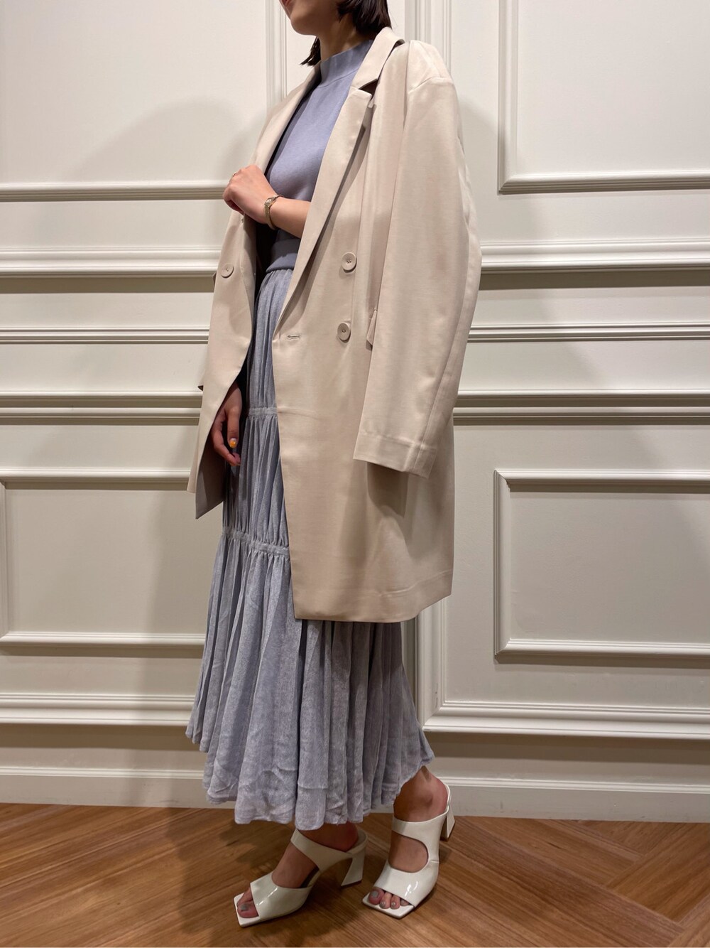 ホワイト系のサンダル、ベージュ系のテーラードジャケット、ブルー系のワンピースを着用したレディースの春コーディネートの3枚目の写真